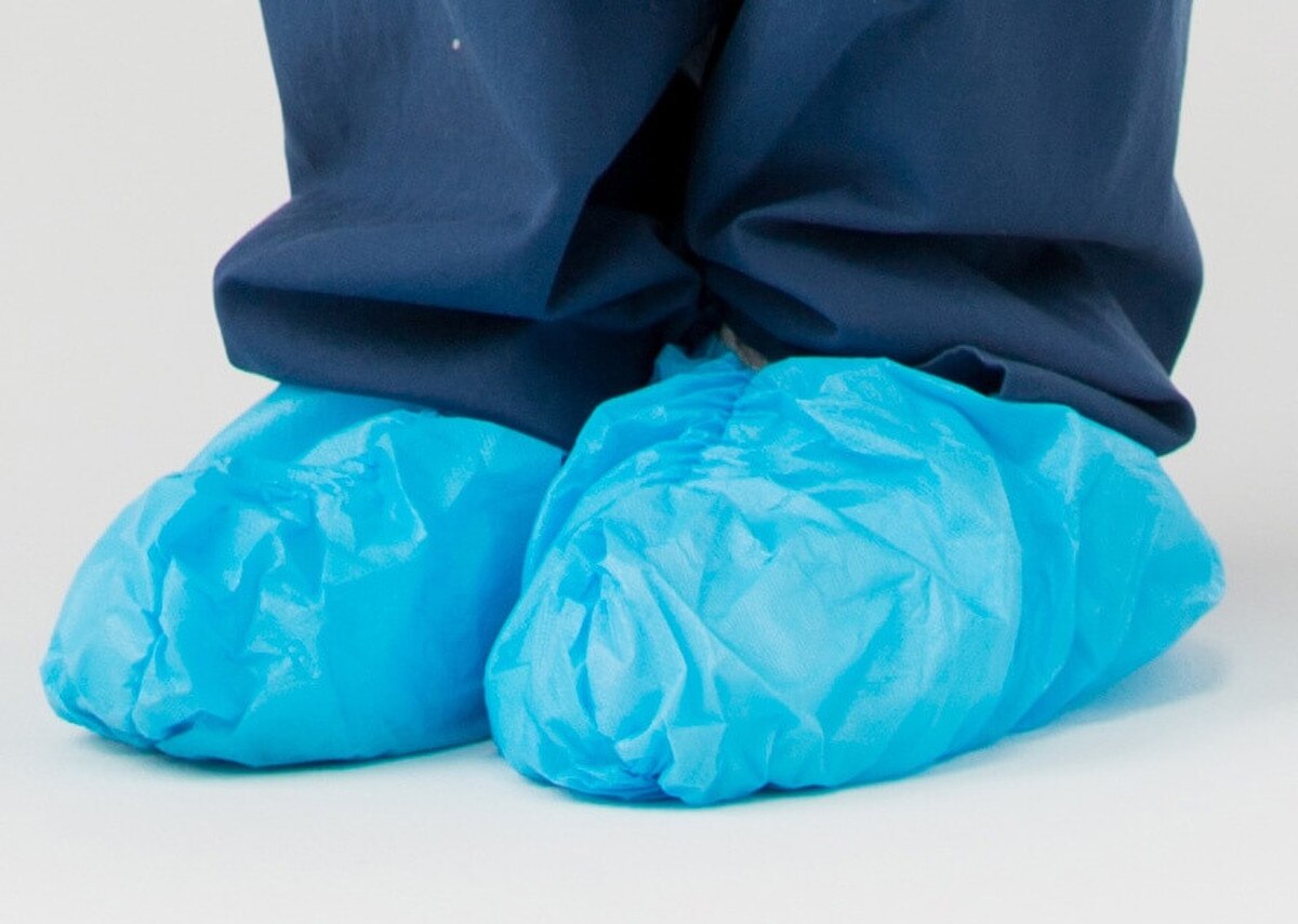 Close-up of blue 16-inch non-sterile disposable shoe covers worn over footwear
